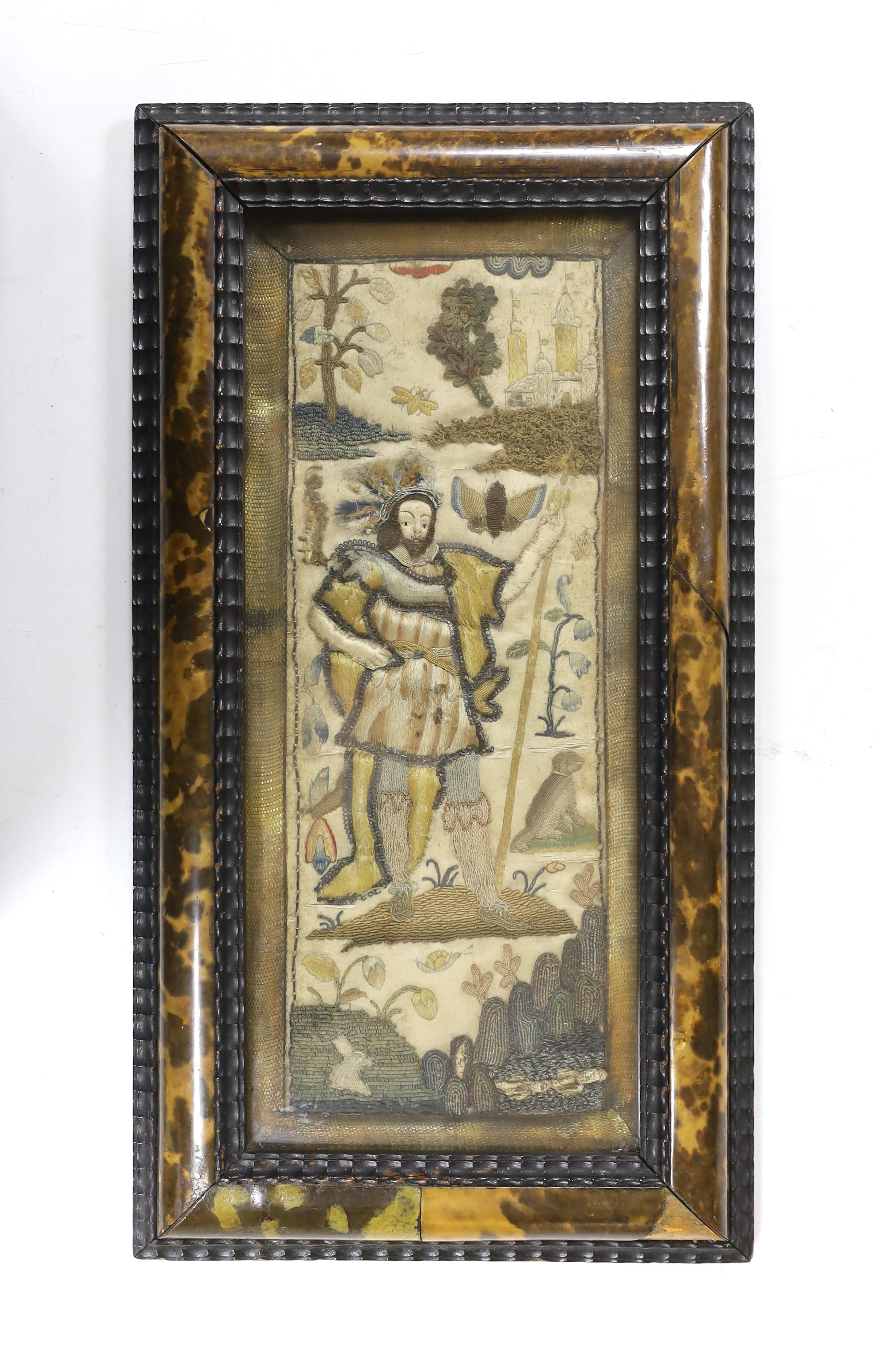 A framed 17th century stumpwork embroidery panel, embroidered with a central figure of a nobleman or king, possibly Henry VIII, holding a staff, wearing a cloth of gold with his dog in the grounds of a castle (possibly N